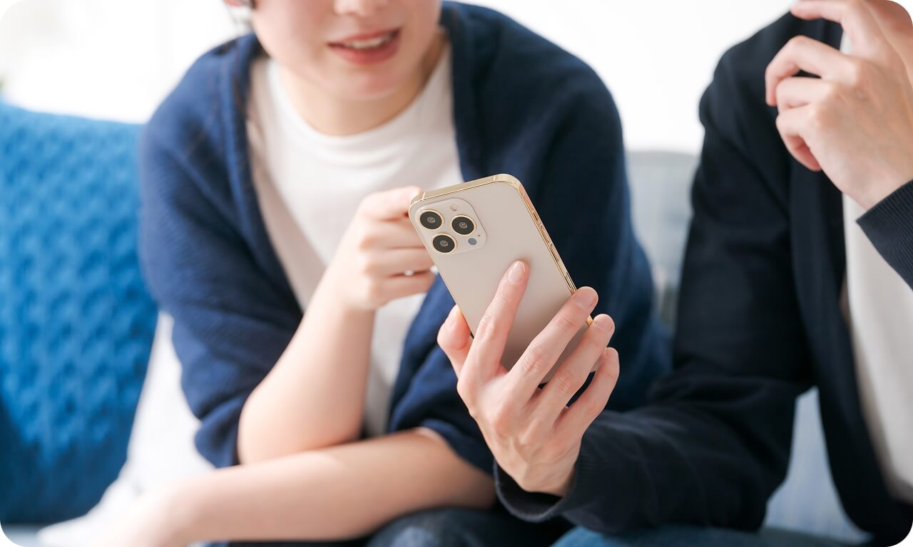 スマートフォンを見ながら来場予約の話をしている様子