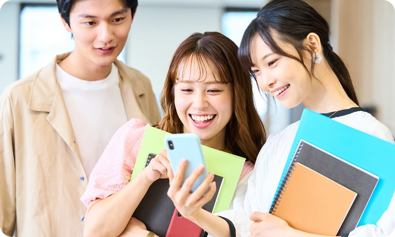 スマートフォンを一緒に見る3人の様子